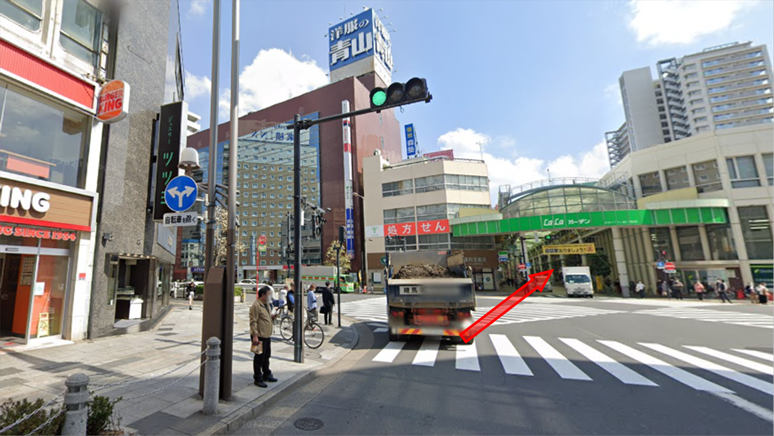 約100m進み交差点を直進して商店街へ進む